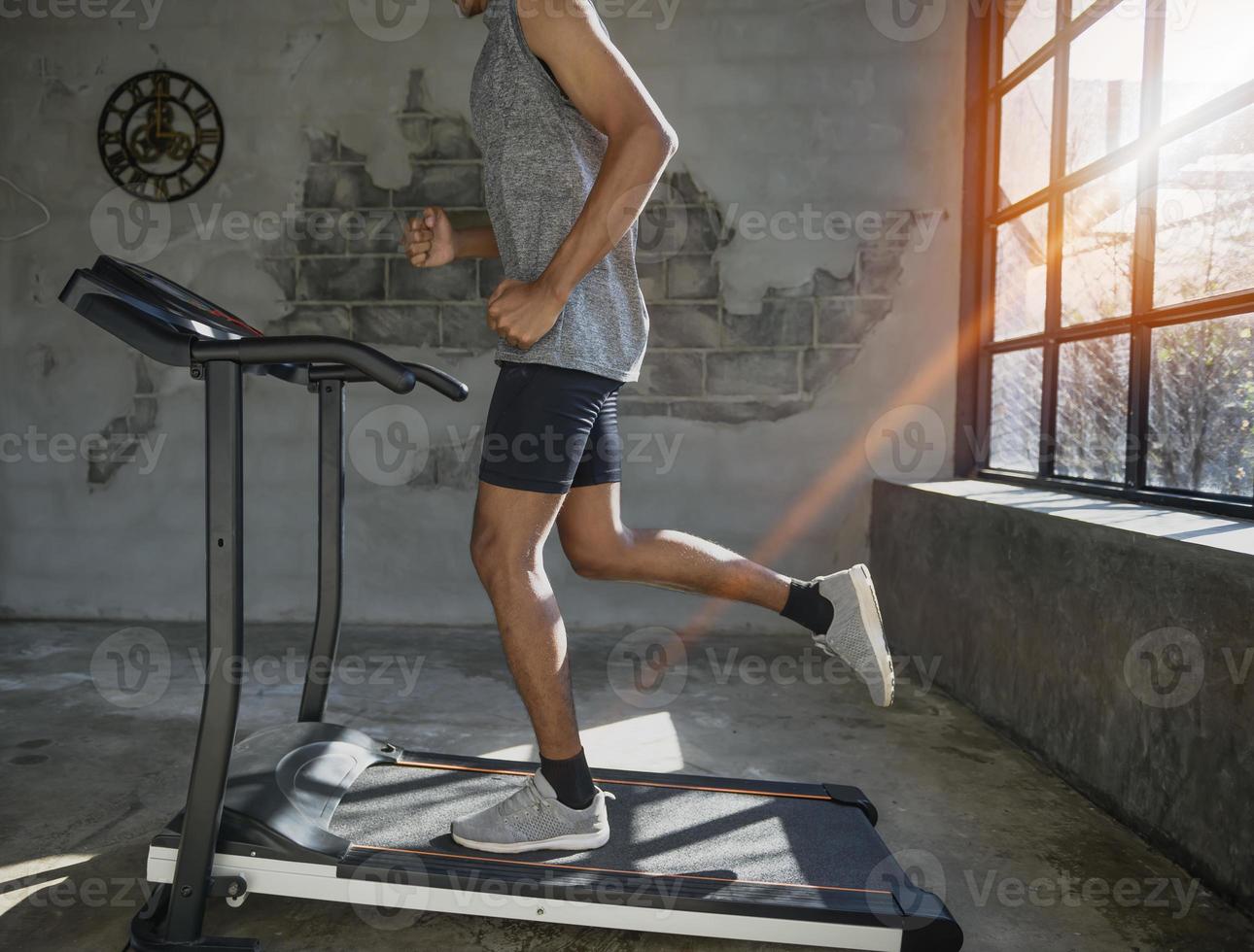 ein Mann, der auf einem Laufband läuft und trainiert. foto