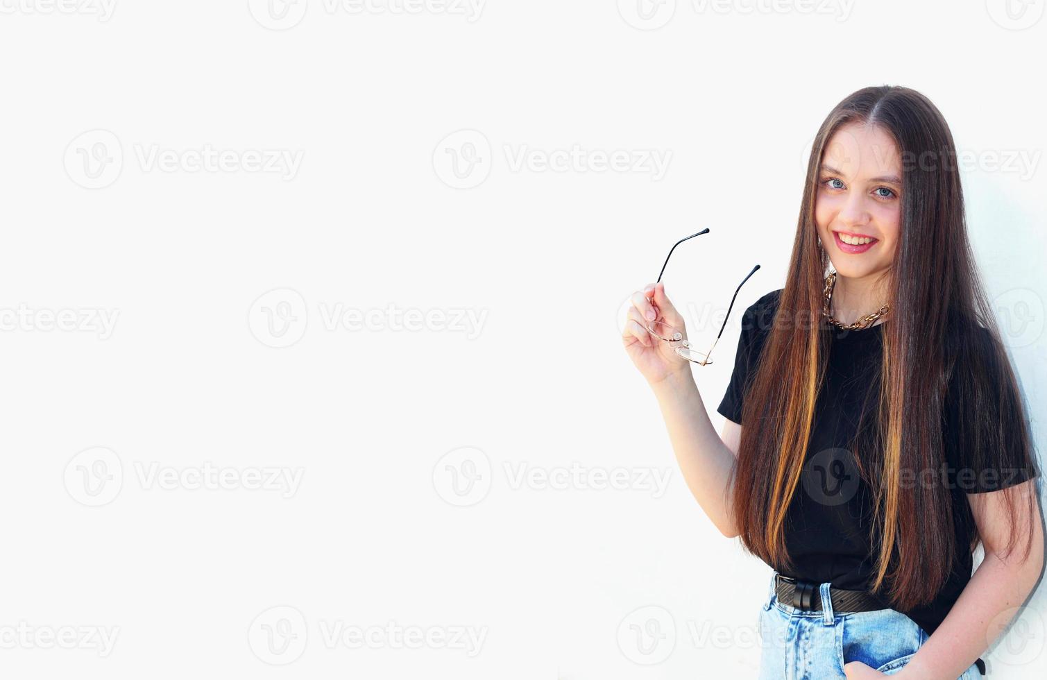 lächelndes Mädchen nimmt Brille nach Sehkorrektur mit Platz zum Einfügen von Text auf weißem Hintergrund ab foto