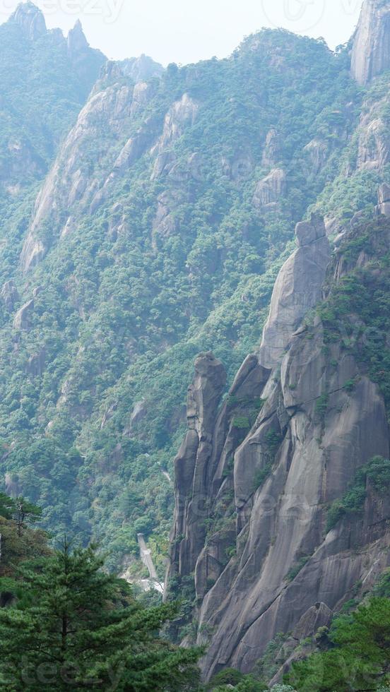 die wunderschönen berglandschaften mit dem grünen wald und der ausgebrochenen felsenklippe als hintergrund in der landschaft des chinas foto
