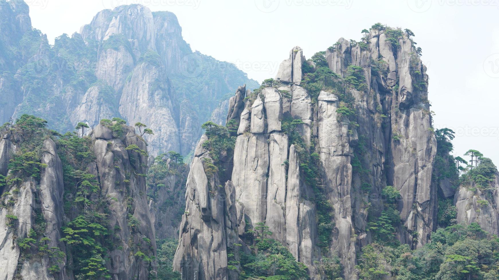 die wunderschönen berglandschaften mit dem grünen wald und der ausgebrochenen felsenklippe als hintergrund in der landschaft des chinas foto