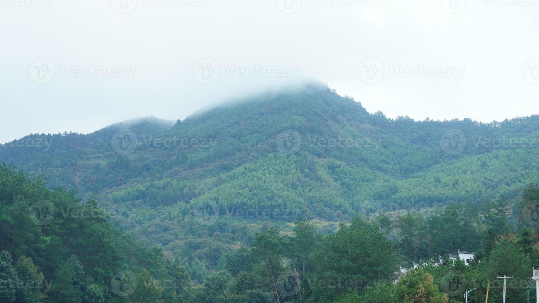 die schönen berglandschaften mit dem grünen wald und dem kleinen dorf als hintergrund in der landschaft des china foto