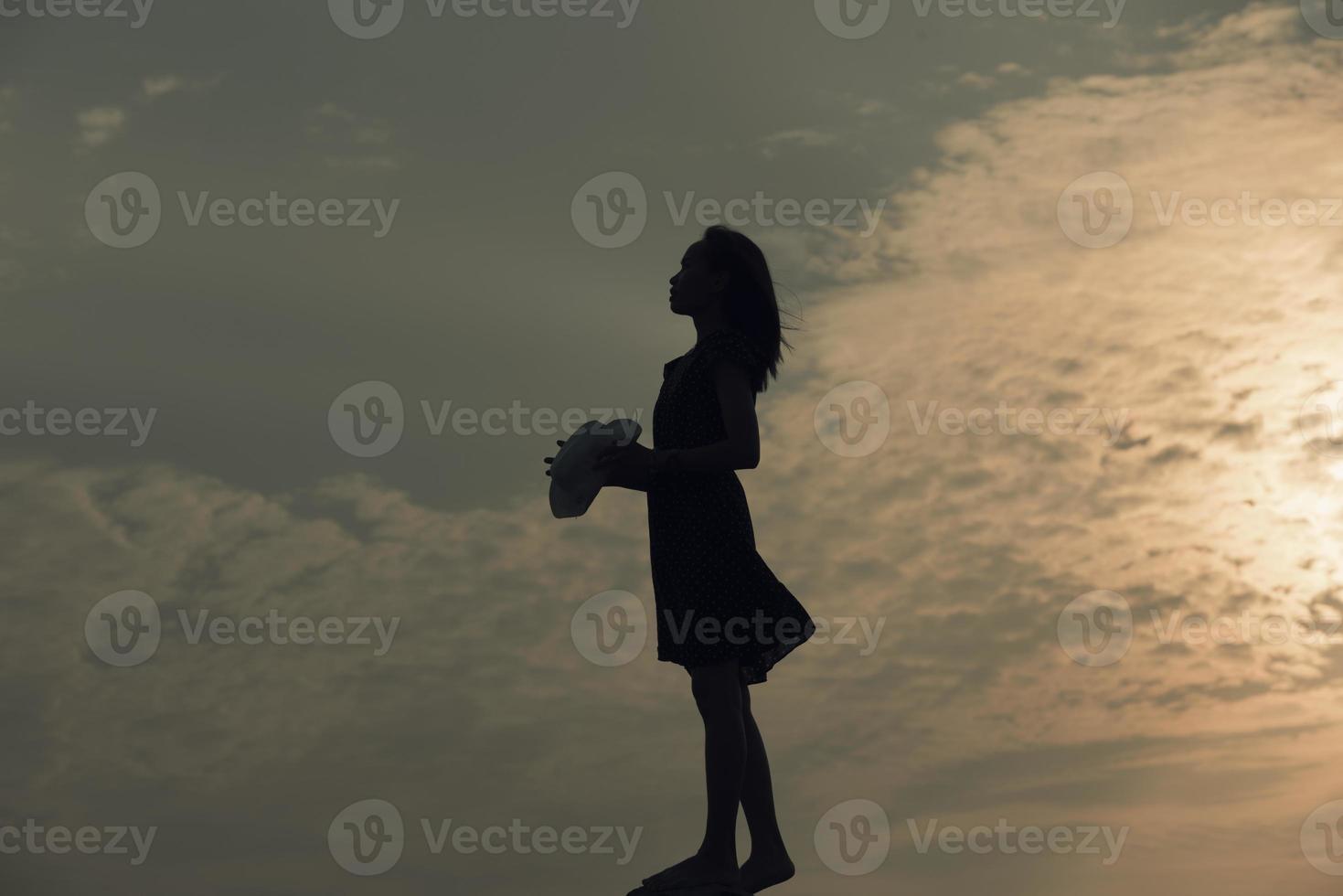 Silhouette trauriges Mädchen bei Sonnenuntergang. foto