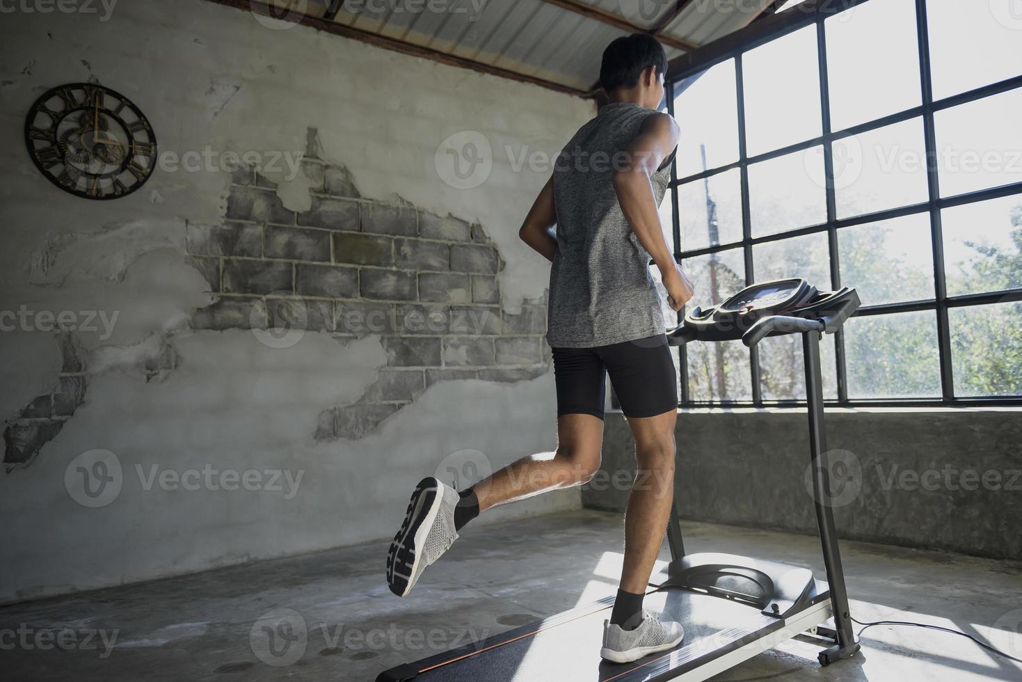 ein Mann, der auf einem Laufband läuft und trainiert. foto