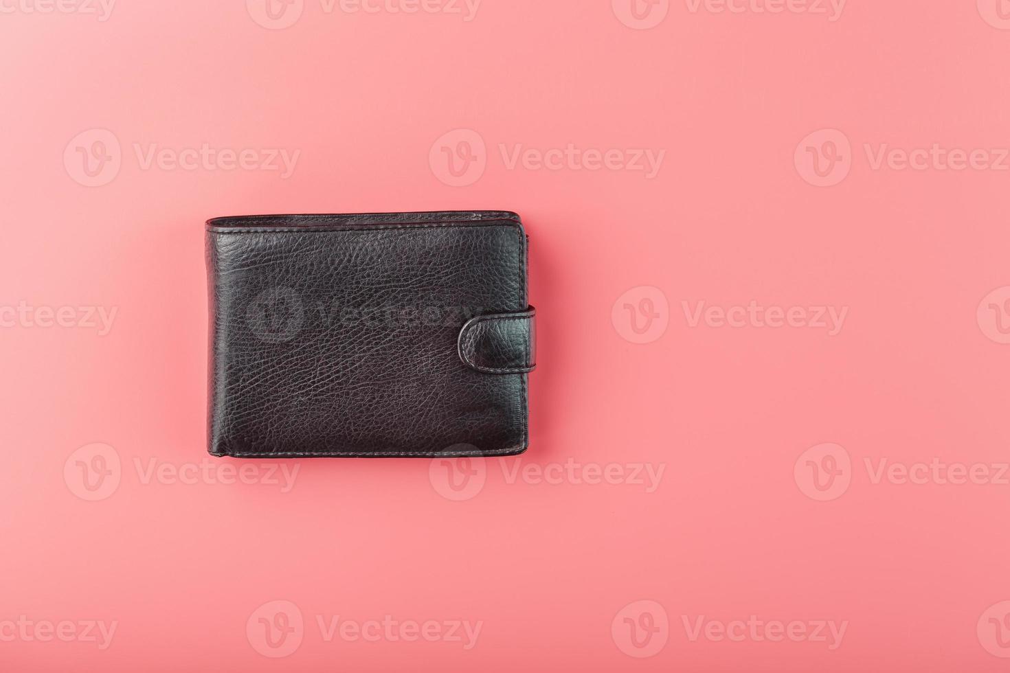 schwarze Geldbörse auf rosa Hintergrund. Symbol für Wohlstand und Wohlstand. foto