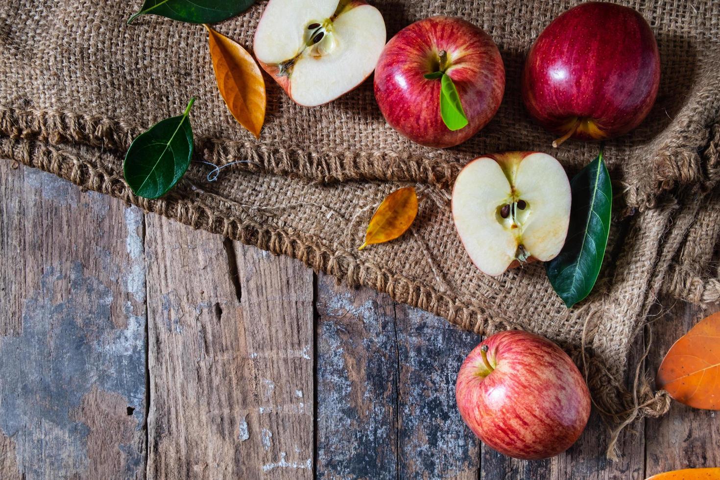 rote Äpfel auf einem alten Holztisch foto