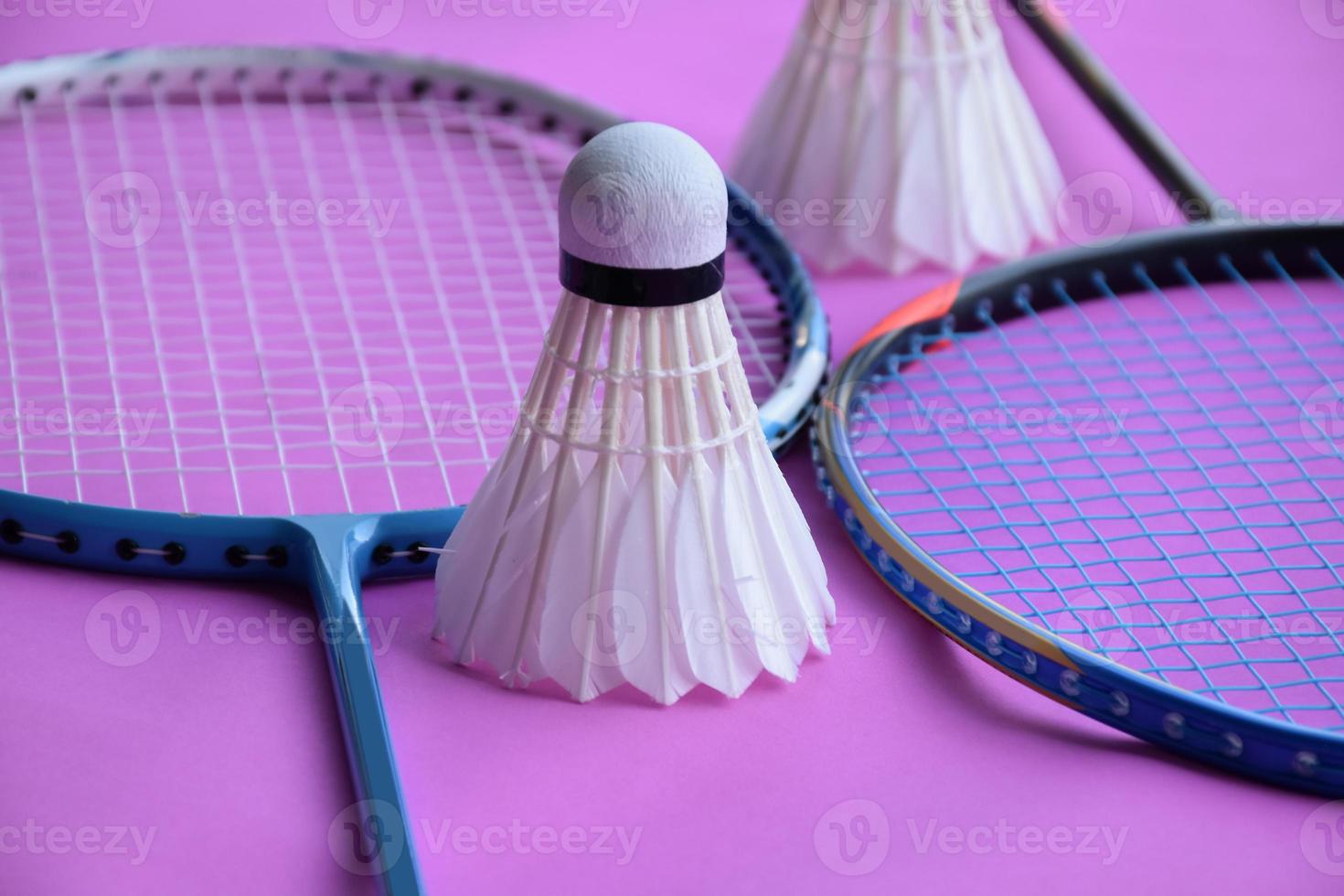 Cremeweißer Badminton-Shuttlecock und Schläger auf dem Boden im Indoor-Badmintonplatz, Kopierraum, weicher und selektiver Fokus auf Federbälle. foto