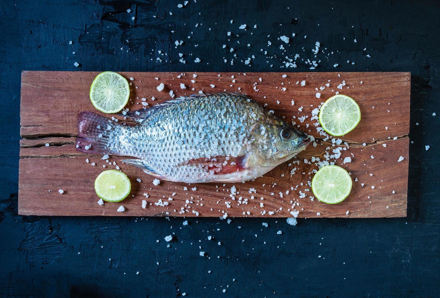 frischer Tilapia-Fisch auf Holzbrett foto