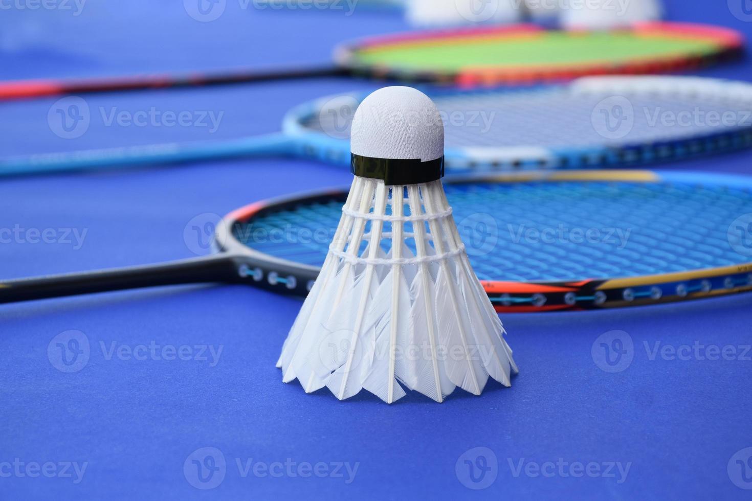 Cremeweißer Badminton-Shuttlecock und Schläger auf dem Boden im Indoor-Badmintonplatz, Kopierraum, weicher und selektiver Fokus auf Federbälle. foto