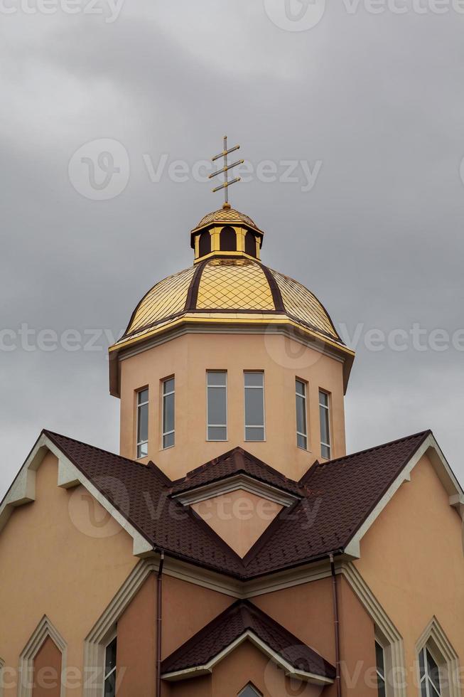 orthodoxe kirche mit goldenen kuppeln und kreuz gegen blauen himmel foto