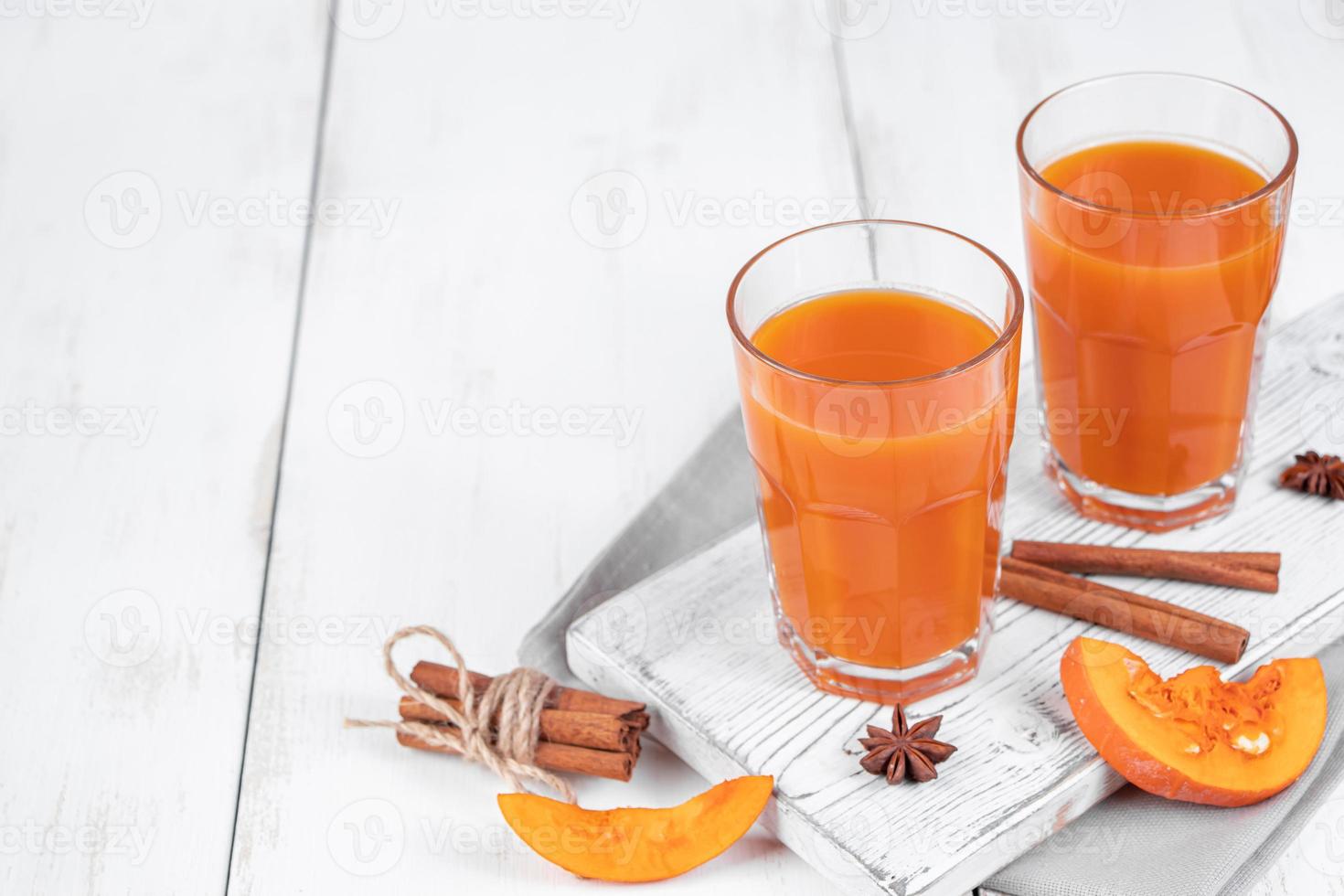 Zwei Gläser Kürbissaft auf weißem Holzhintergrund. pflanzliches Entgiftungsgetränk für eine gesunde Ernährung. foto