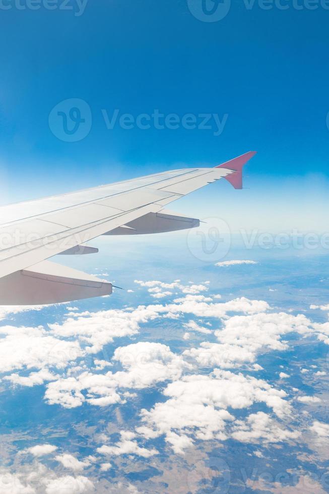 Flugzeugflügel auf den Wolken, fliegt auf dem Berghintergrund foto