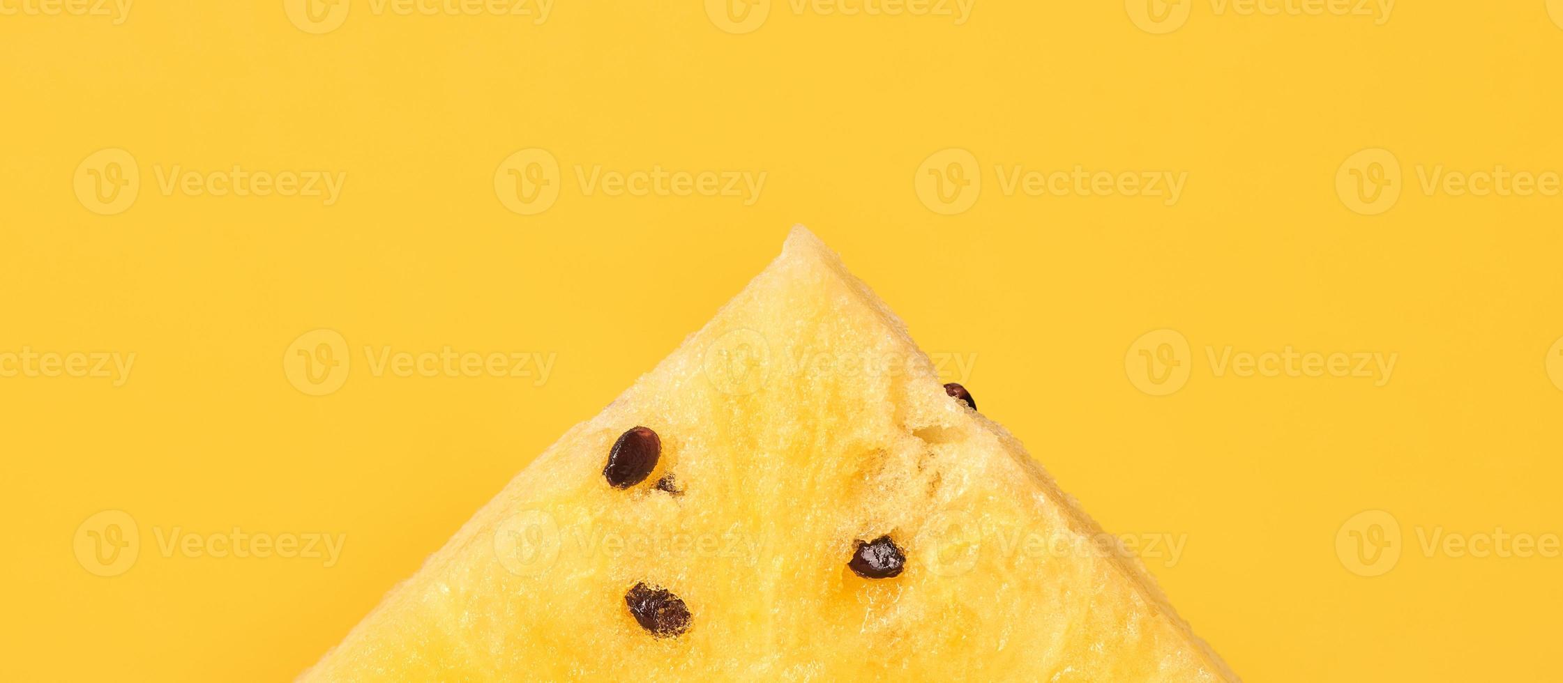 Ein Stück gelbe Wassermelone mit Samen auf gelbem Hintergrund, köstliche erfrischende Frucht foto