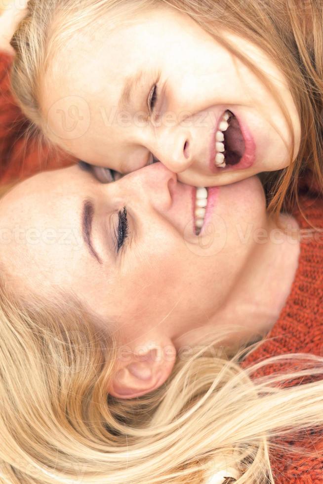 Mädchen und Mutter liegen auf Herbstlaub foto