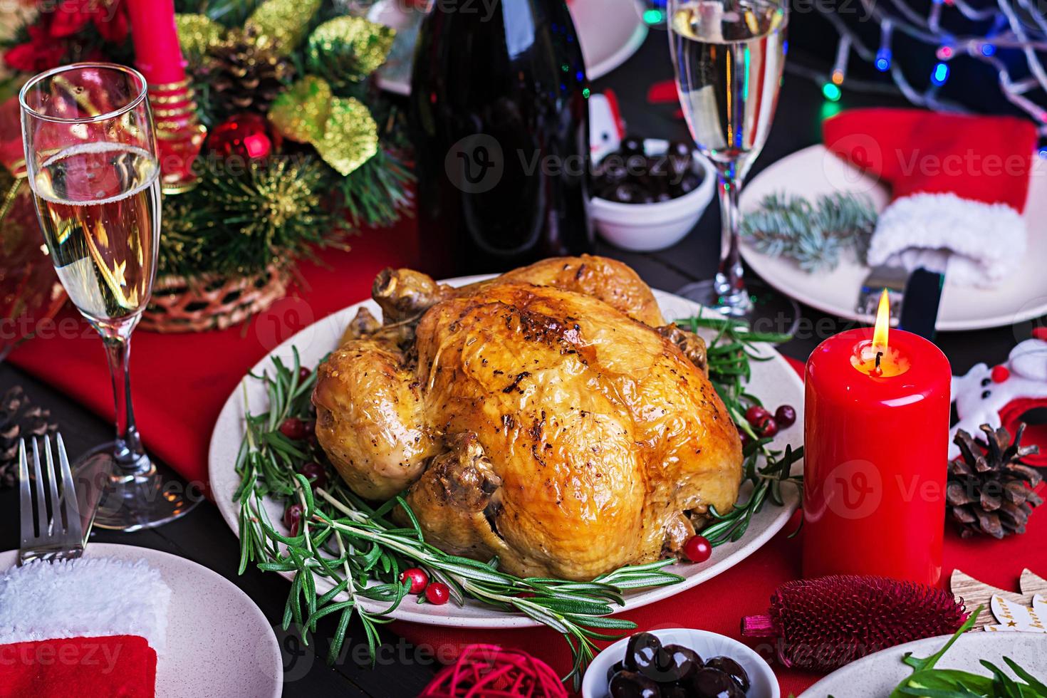 gebackener Truthahn. Weihnachtsessen. Der Weihnachtstisch wird mit einem Truthahn serviert, der mit leuchtendem Lametta und Kerzen dekoriert ist. Brathähnchen, Tisch. Familienessen. foto