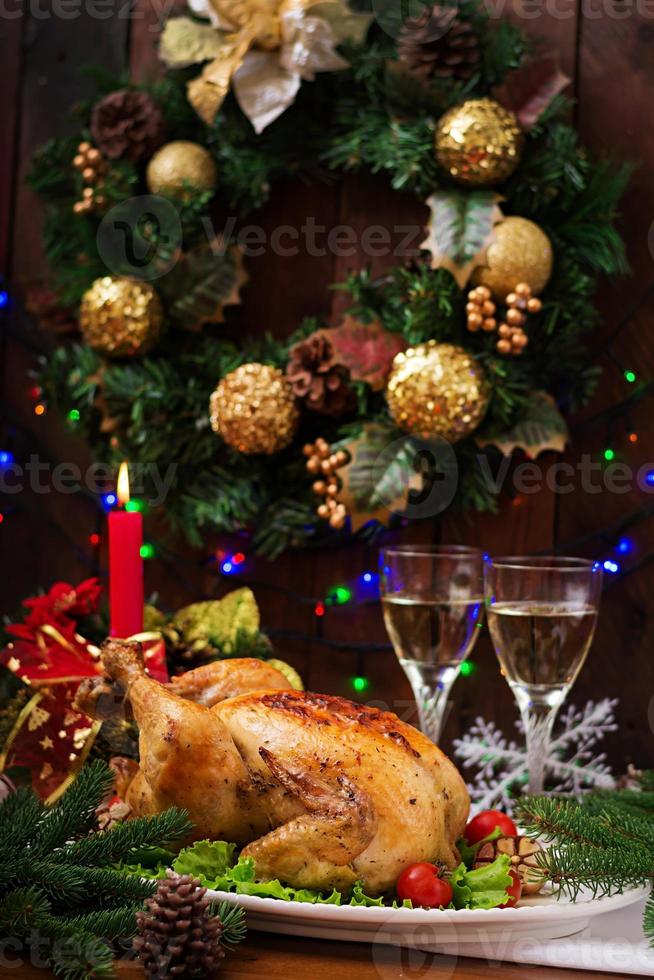 gebackener Truthahn oder Huhn. Der Weihnachtstisch wird mit einem Truthahn serviert, der mit leuchtendem Lametta und Kerzen dekoriert ist. Brathähnchen, Tisch. Weihnachtsessen. foto