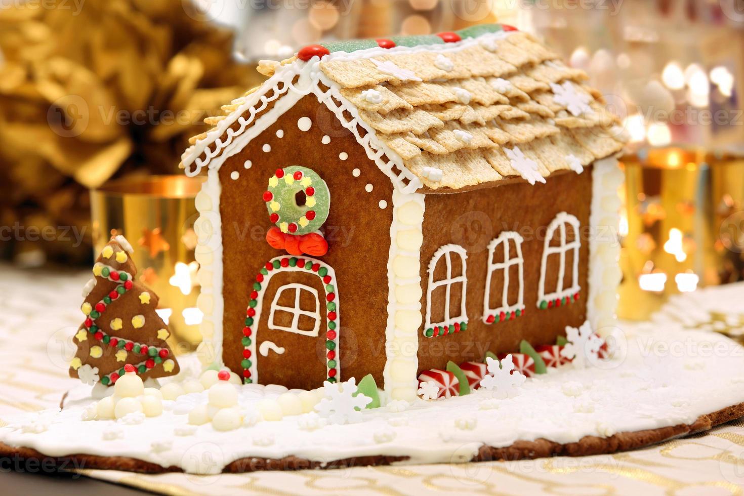 Weihnachts-Lebkuchenhaus auf dem dekorierten Tisch foto