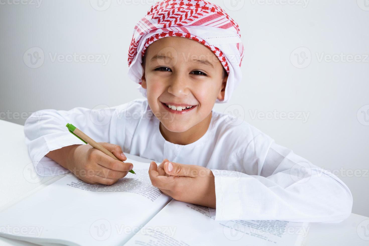 arabischer kleiner Junge, der Hausaufgaben macht foto