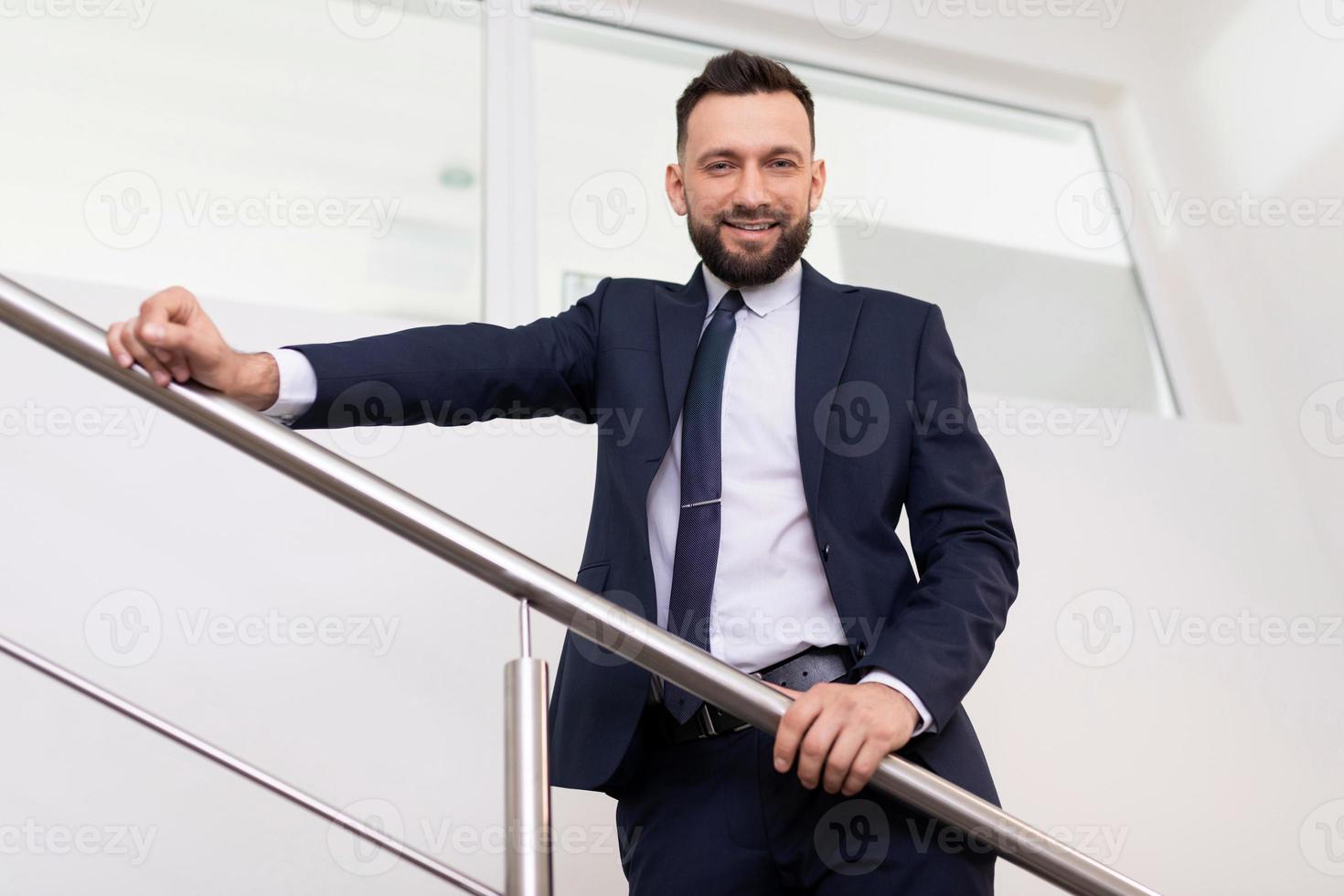 Vorzeigbarer Hauptmann in einem Business-Anzug auf der Treppe von unten, Konzept eines erfolgreichen Unternehmensleiters foto