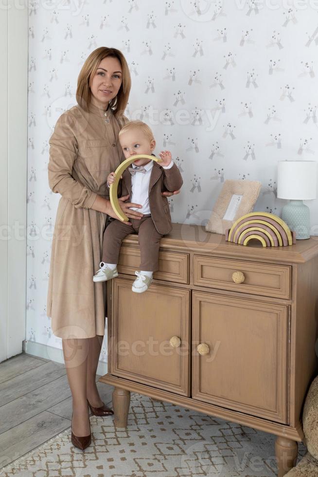 mutter mit ihrem kleinen sohn in bodenlanger kräftiger businesskleidung foto