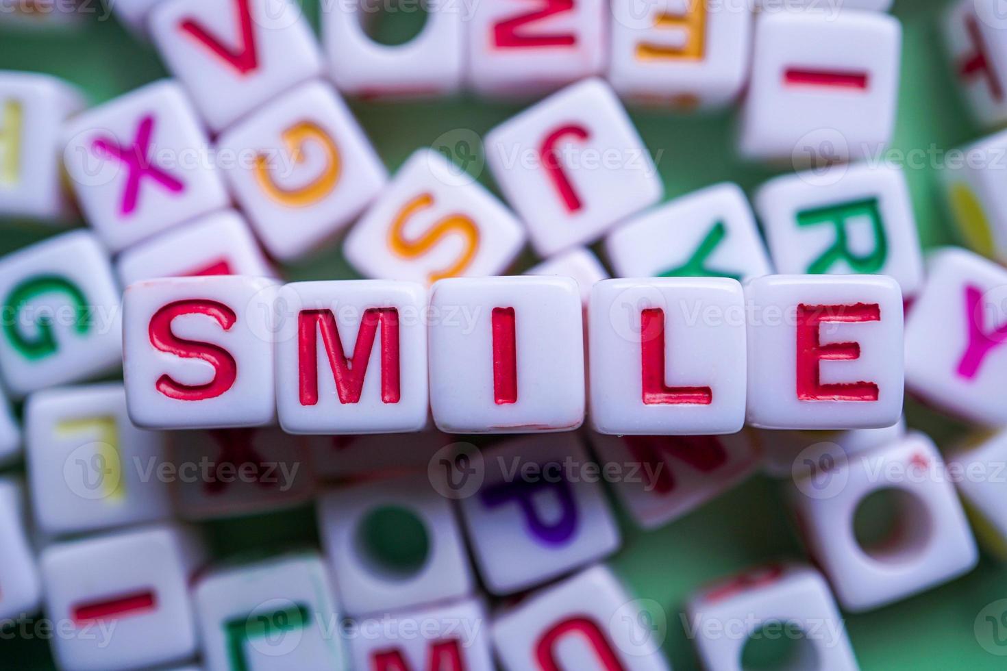 Lächelnwort mit roten Würfelbuchstaben, Gefühlen und Emotionen foto