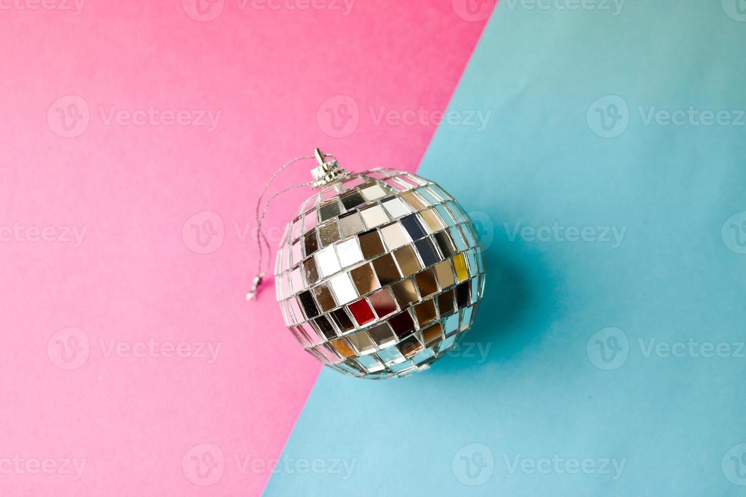 silber spiegel musical club disco ball klein rund glas winter glänzend dekorativ schön weihnachten festlich weihnachtskugel, weihnachtsspielzeug verputzt auf glitzern auf einem grau rosa lila hintergrund foto