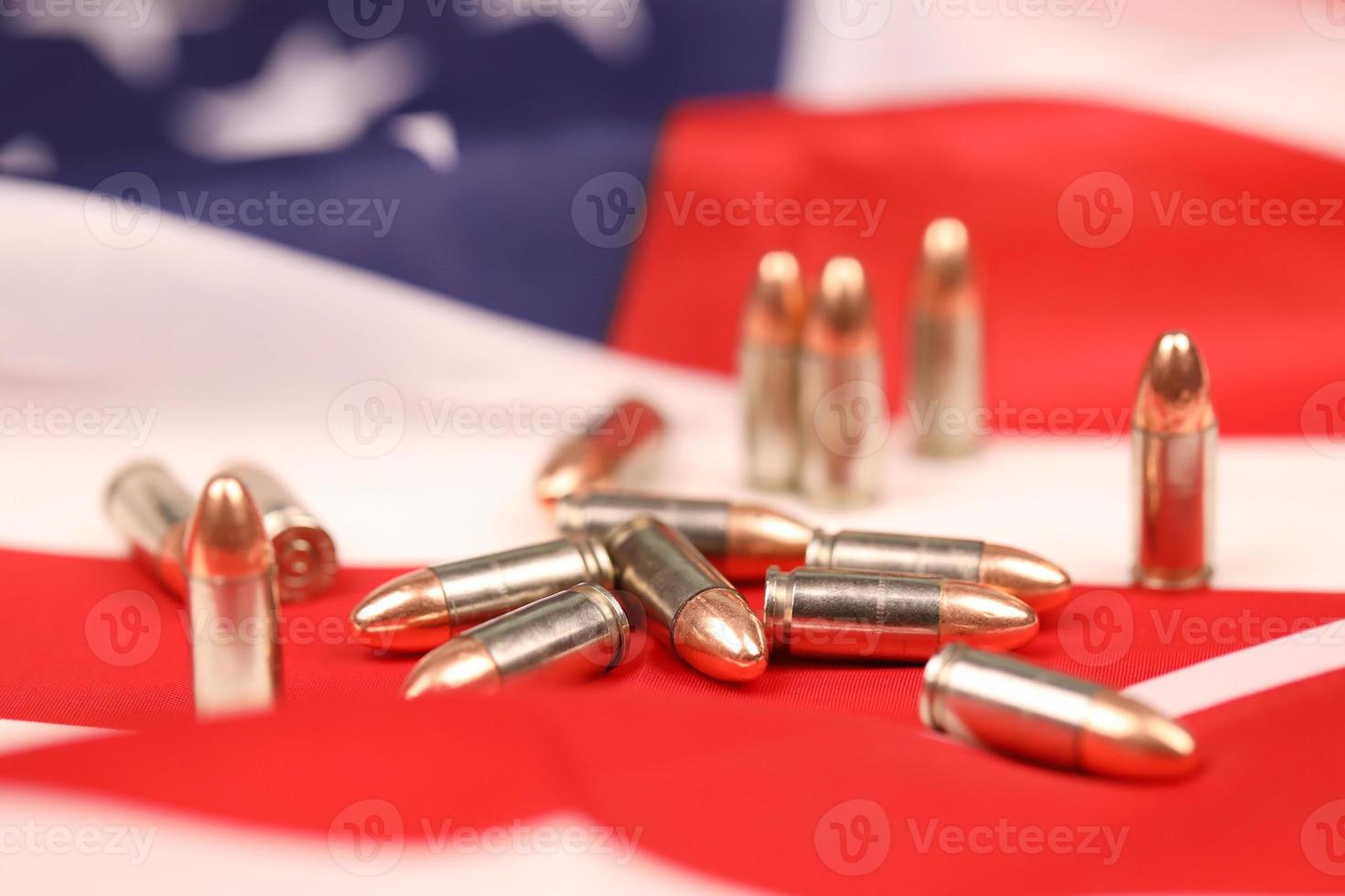Viele gelbe 9-mm-Kugeln und Patronen auf der Flagge der Vereinigten Staaten. Konzept des Waffenhandels auf US-Territorium oder Spezialoperationen foto