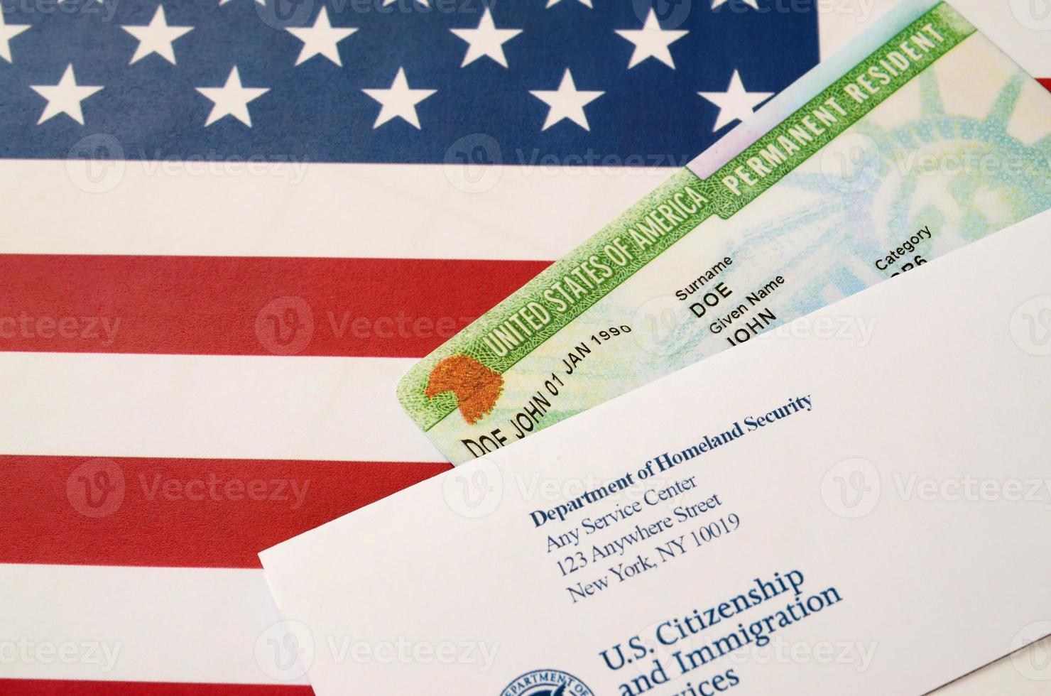 United States Permanent Resident Green Card von der DV-Lotterie liegt auf der Flagge der Vereinigten Staaten mit Umschlag vom Department of Homeland Security foto