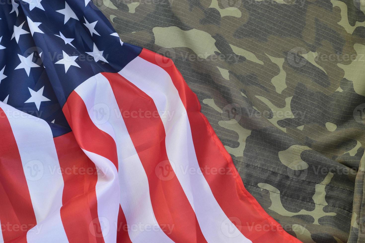 Flagge der Vereinigten Staaten von Amerika und gefaltete Militäruniformjacke. militärische symbole konzeptioneller hintergrundbanner für amerikanische patriotische feiertage foto