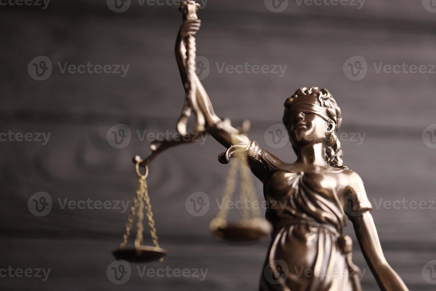 die Statue der Gerechtigkeit - Lady Justice oder Justitia die römische Göttin der Gerechtigkeit. Statue auf schwarzer Holzwand. konzept des gerichtsverfahrens, des gerichtsverfahrens und der arbeit der anwälte foto