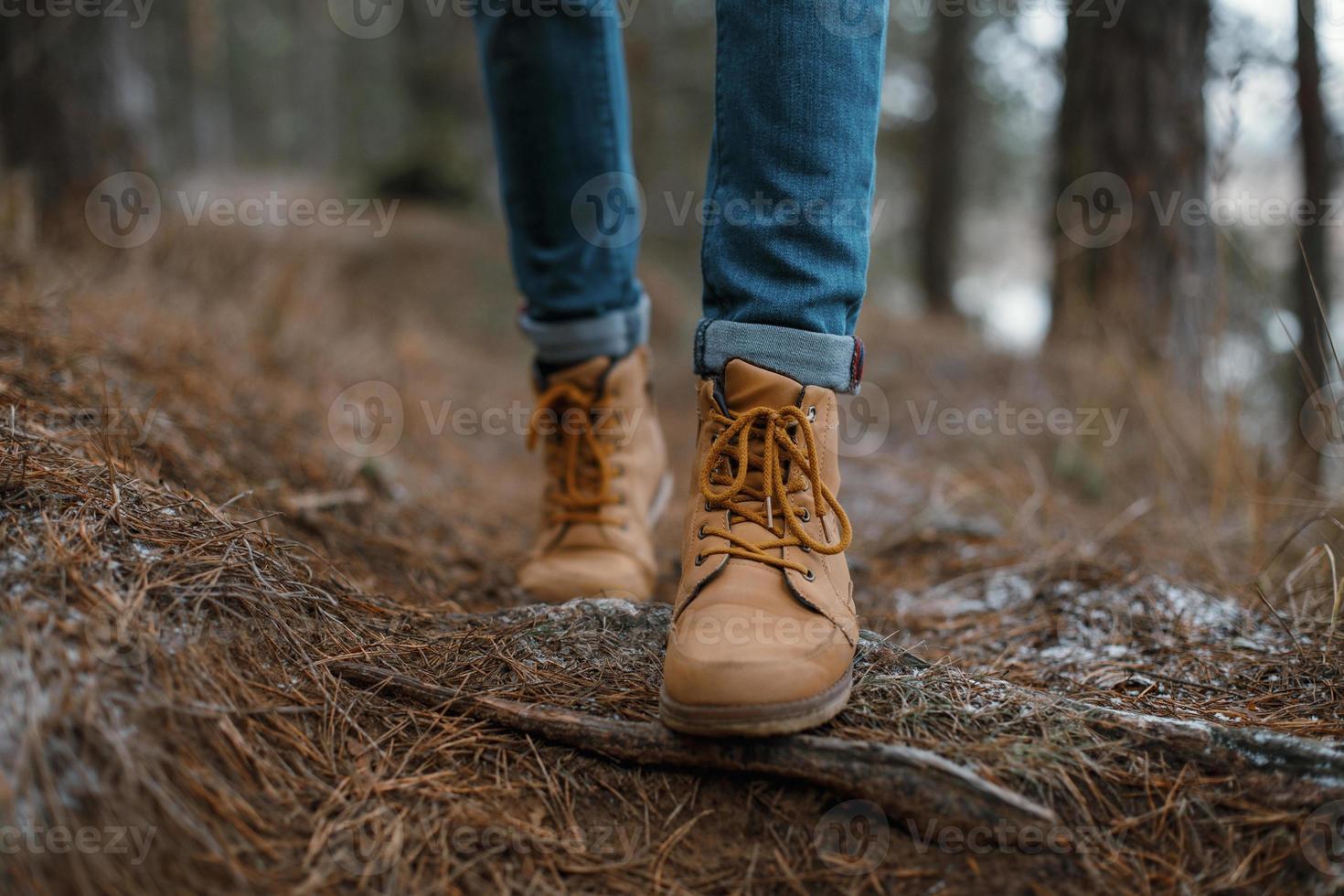 Nahaufnahme von Beinen, die im Wald spazieren gehen foto