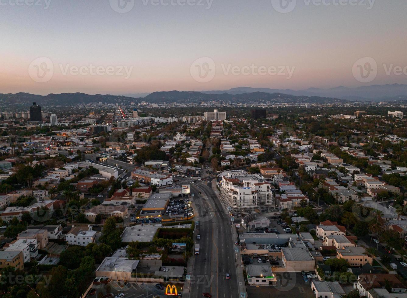 Blick auf den heißen Sonnenuntergang von Los Angeles mit Palmen und der Innenstadt im Hintergrund. foto