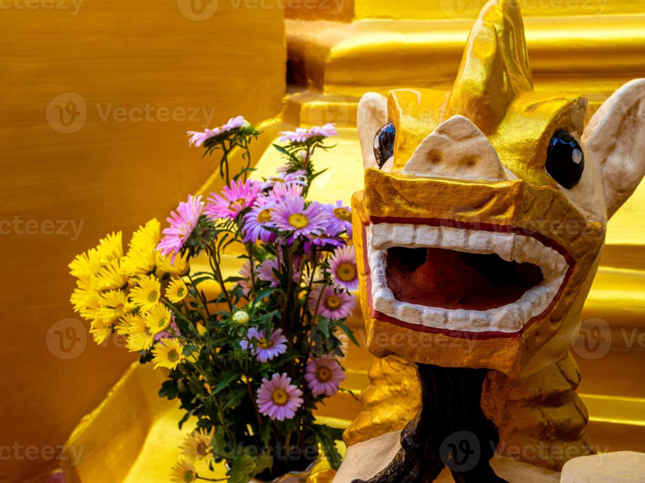 ein Blumenstrauß für die Anbetung und eine Löwenstatue aus Burma am Fuß der Pagode foto