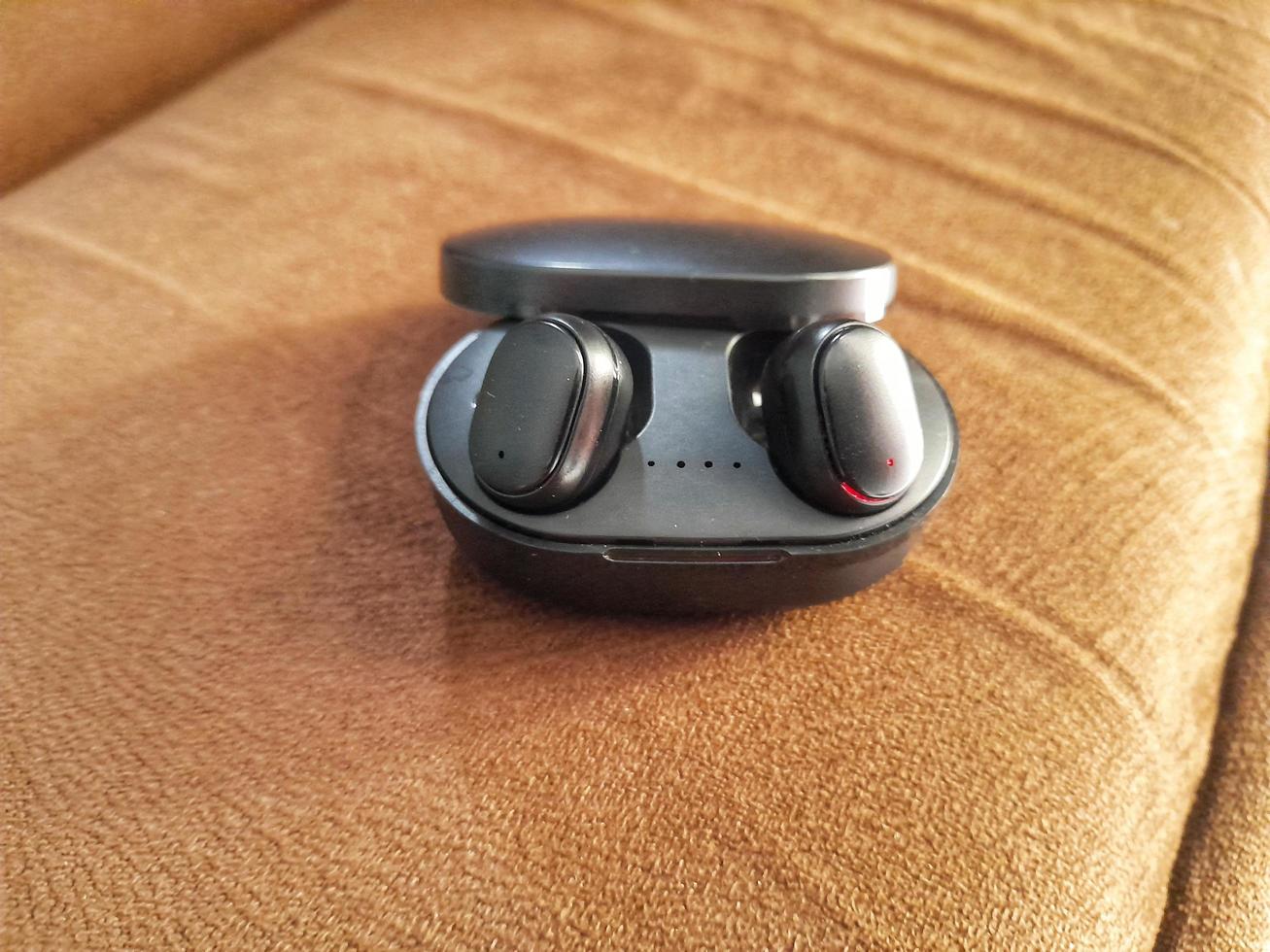 schwarzer Bluetooth-Kopfhörer auf braunem Hintergrund foto