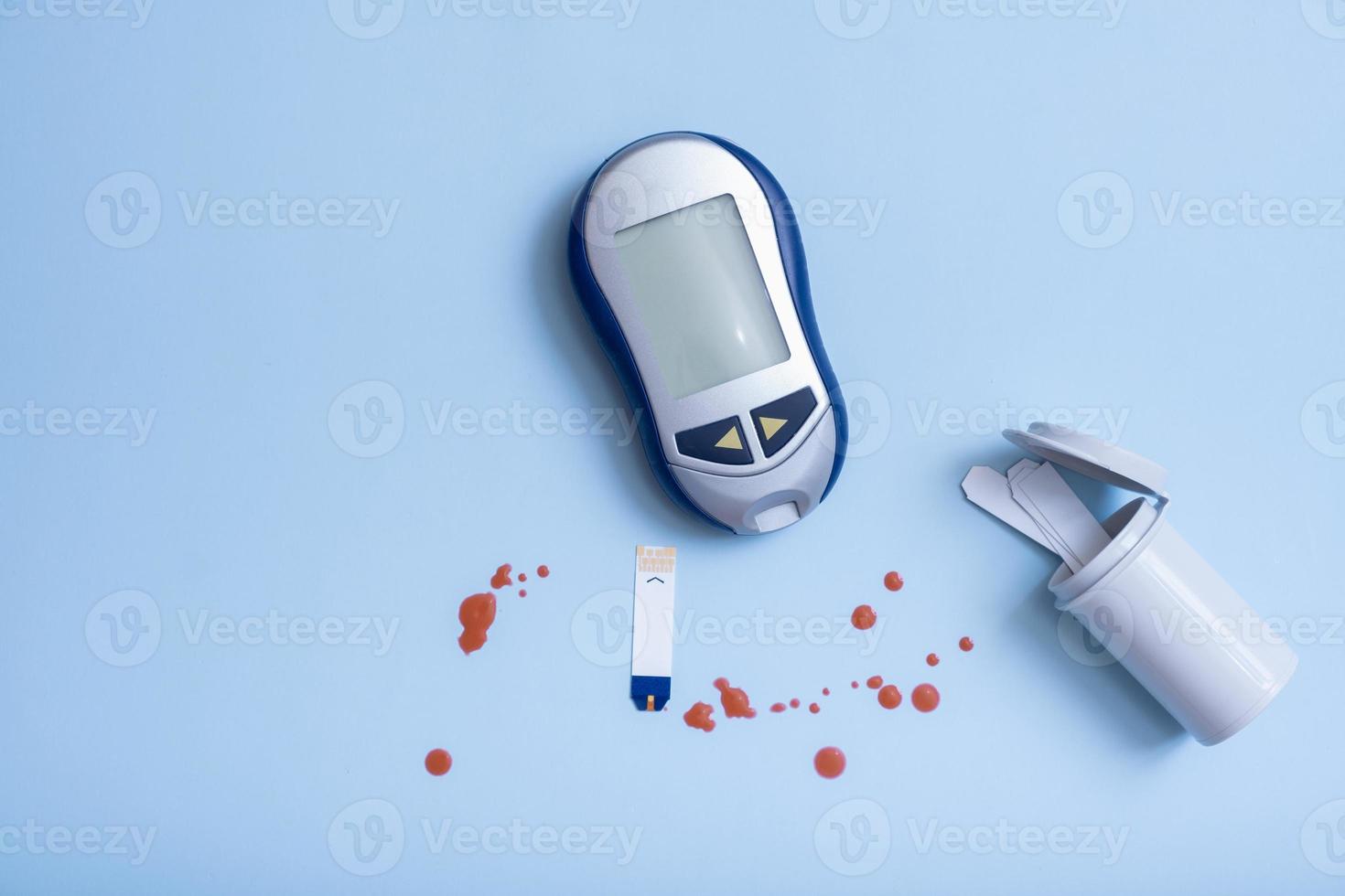 top vie zuckermessgerät und blutstropfen auf blauem hintergrund. Diabetes-Testkonzept foto