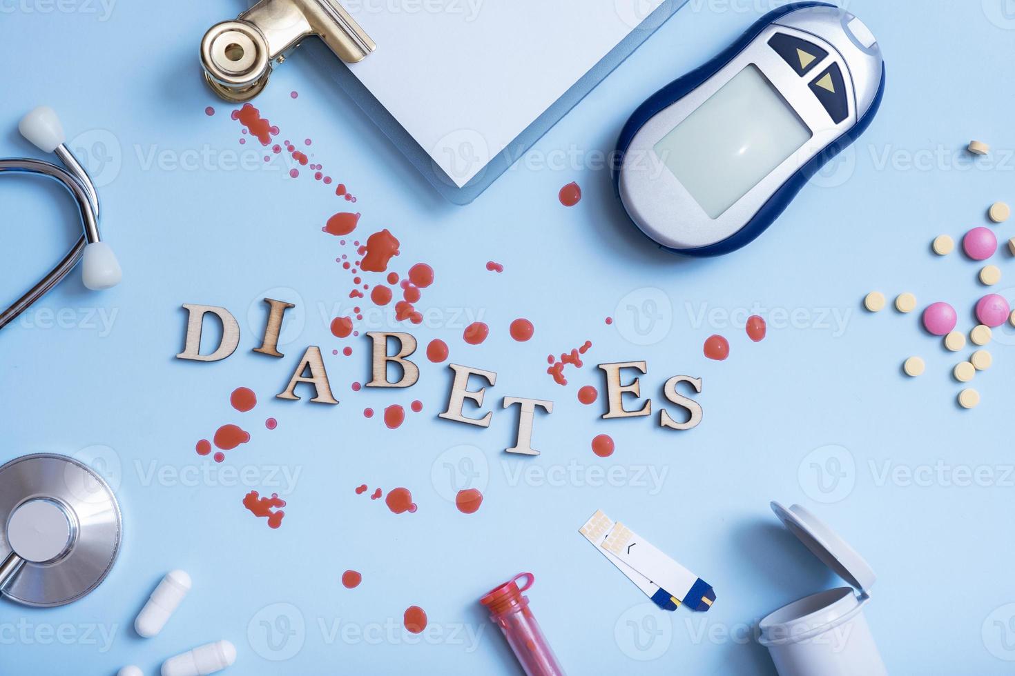 Wortdiabetes mit Insulinspritze, Lanzette, Test, Blutzuckermessgerät auf blauem Hintergrund foto