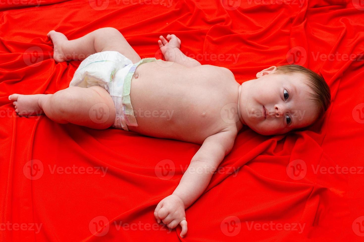 Baby auf einem roten Tuch foto