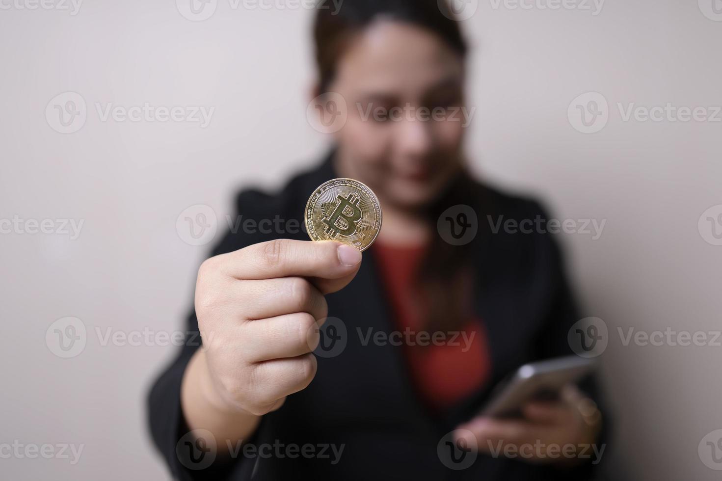 Geschäftsfrau in der Hand Bitcoin-Münzen und Smartphone mit Krypto-Handelsdiagramm. Austausch von Kryptowährungen. digitales konzept für technologie und investitionen. Finanzen, Händler, Investor, Gold-Bitcoin-Bargeld foto