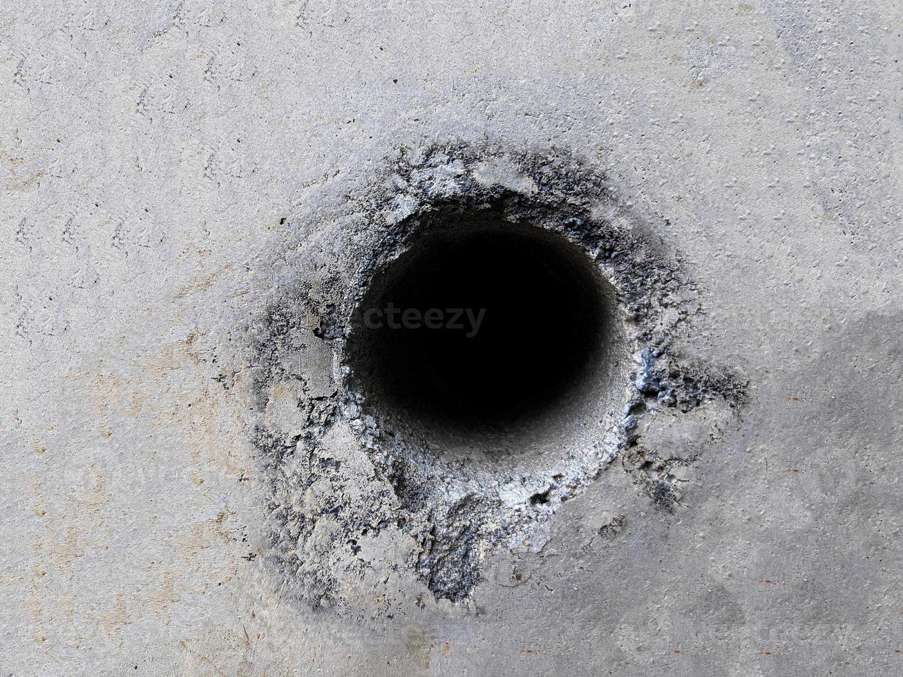 Hintergrundtextur der Zementwand mit Loch in der Mitte foto