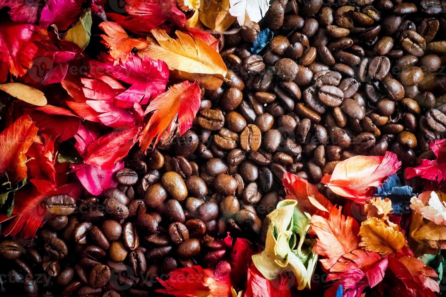 Das Hintergrundbild besteht aus Kaffeebohnen, die mit Blumen geschmückt sind. Hintergrundkonzept für Café foto