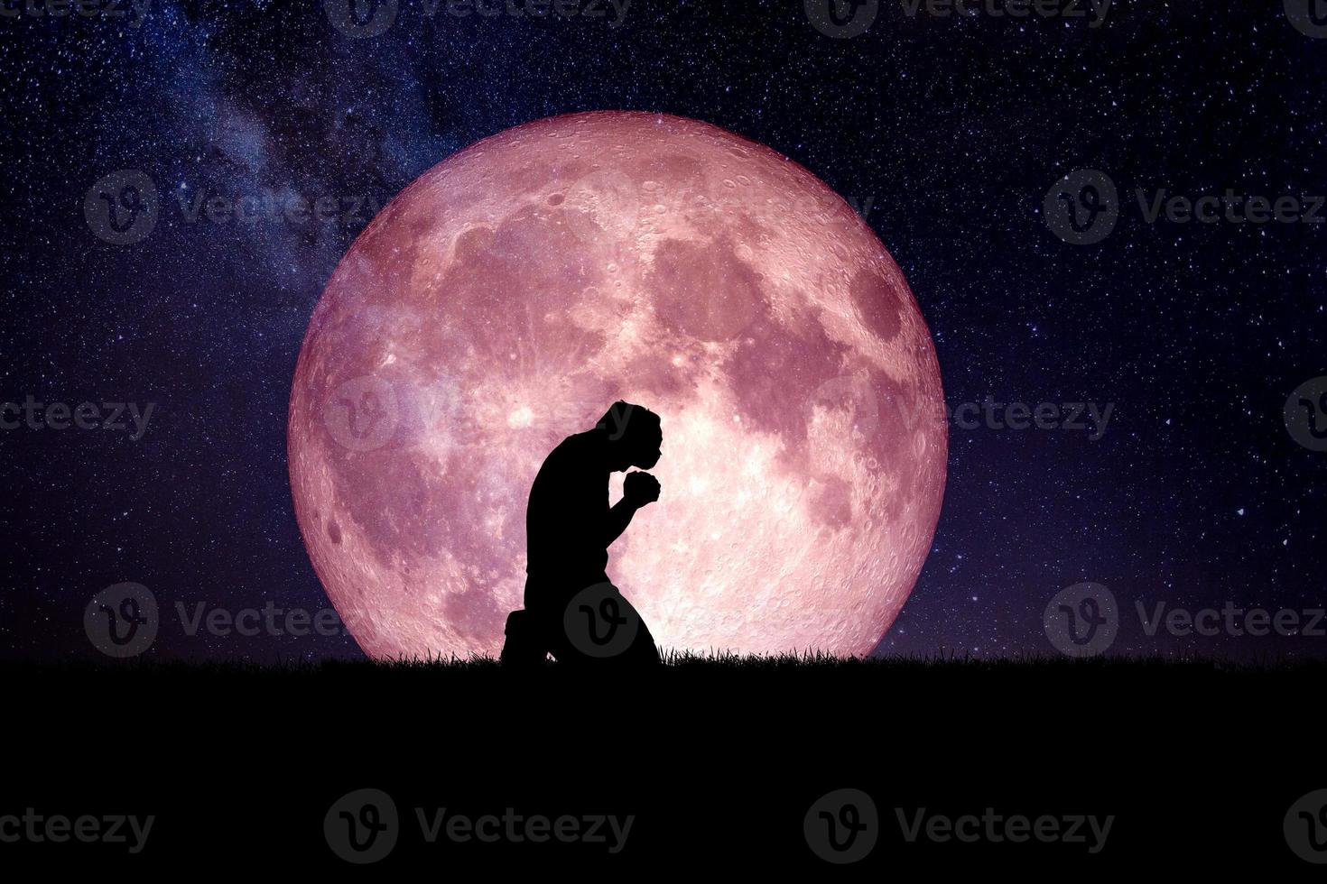 Ein verzweifelter und einsamer Mann kniete nieder und betete zu Gott. Nachts ist im Hintergrund ein Mond. verzweifelte, herzzerreißende und einsame Konzepte foto