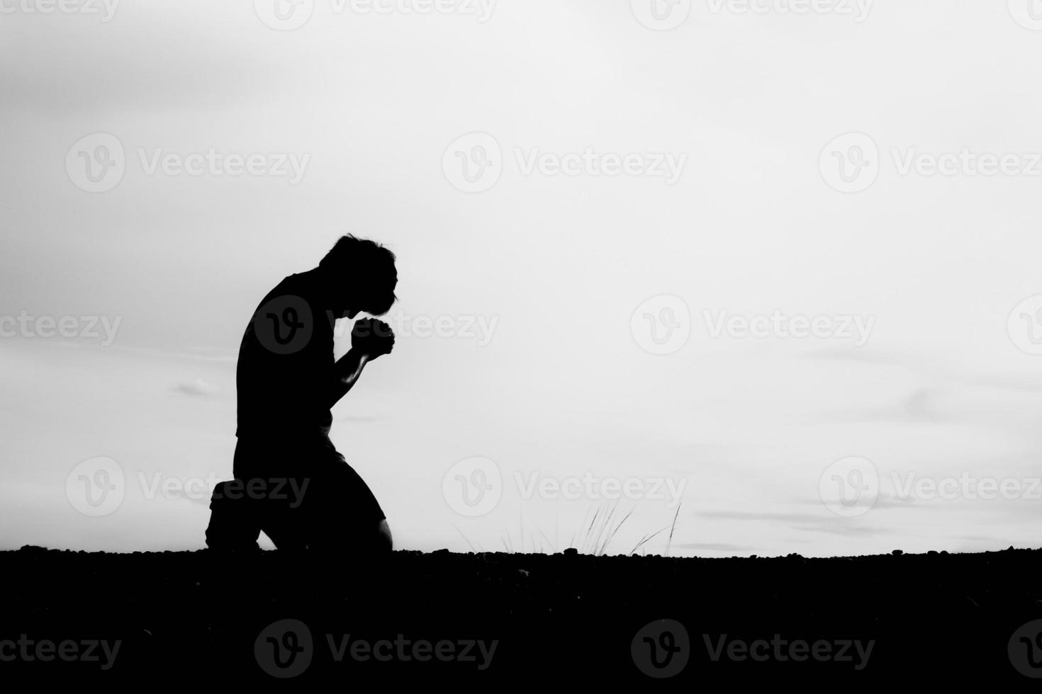 Silhouetten von Männern, die sitzen und um Segen beten. Hoffnungskonzept foto