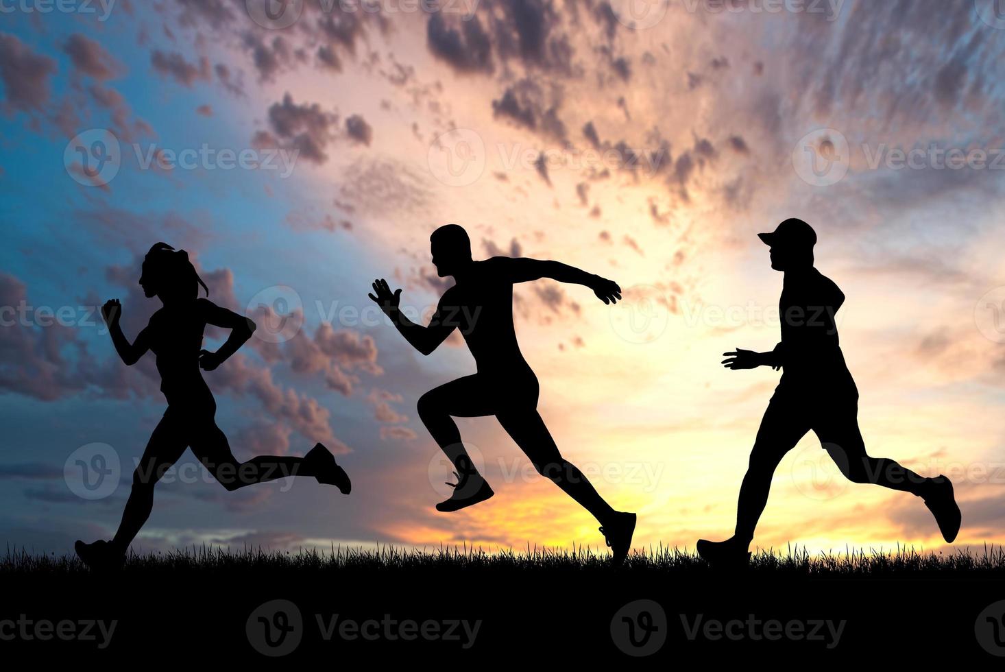 Menschen, die abends auf der Wiese joggen foto