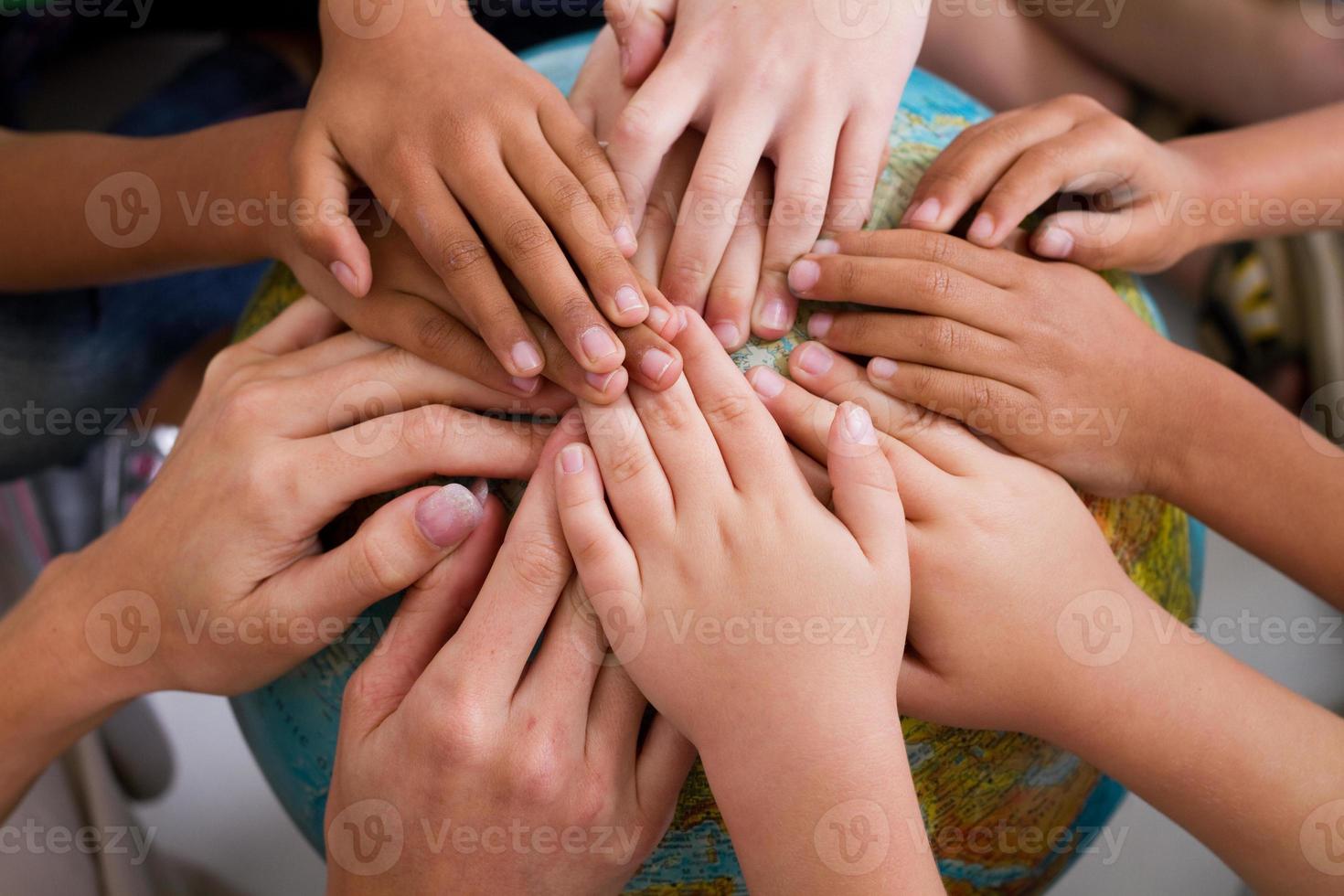 Kinder und Lehrer Hände auf Globus foto