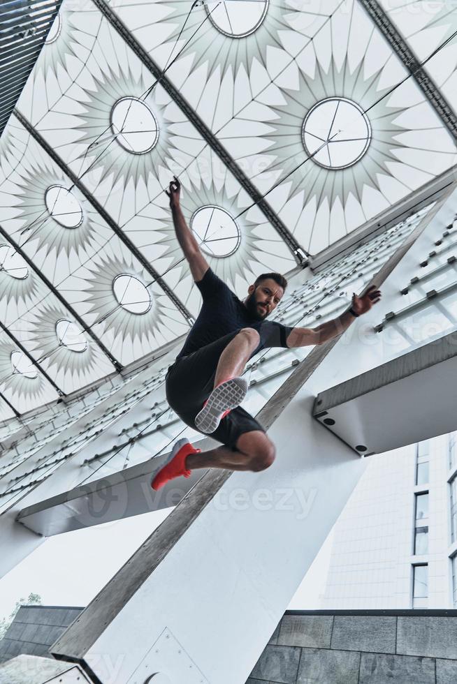 Er ist ein neuer Champion. in voller Länge von einem hübschen jungen Mann in Sportkleidung, der beim Training draußen springt foto