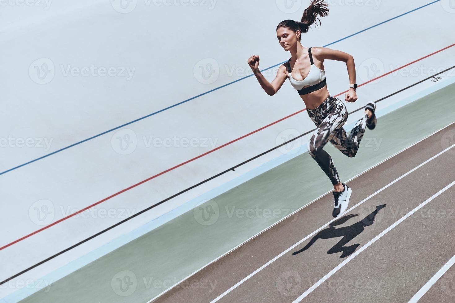 immer in Form. Draufsicht einer jungen Frau in Sportkleidung, die beim Training im Freien springt foto