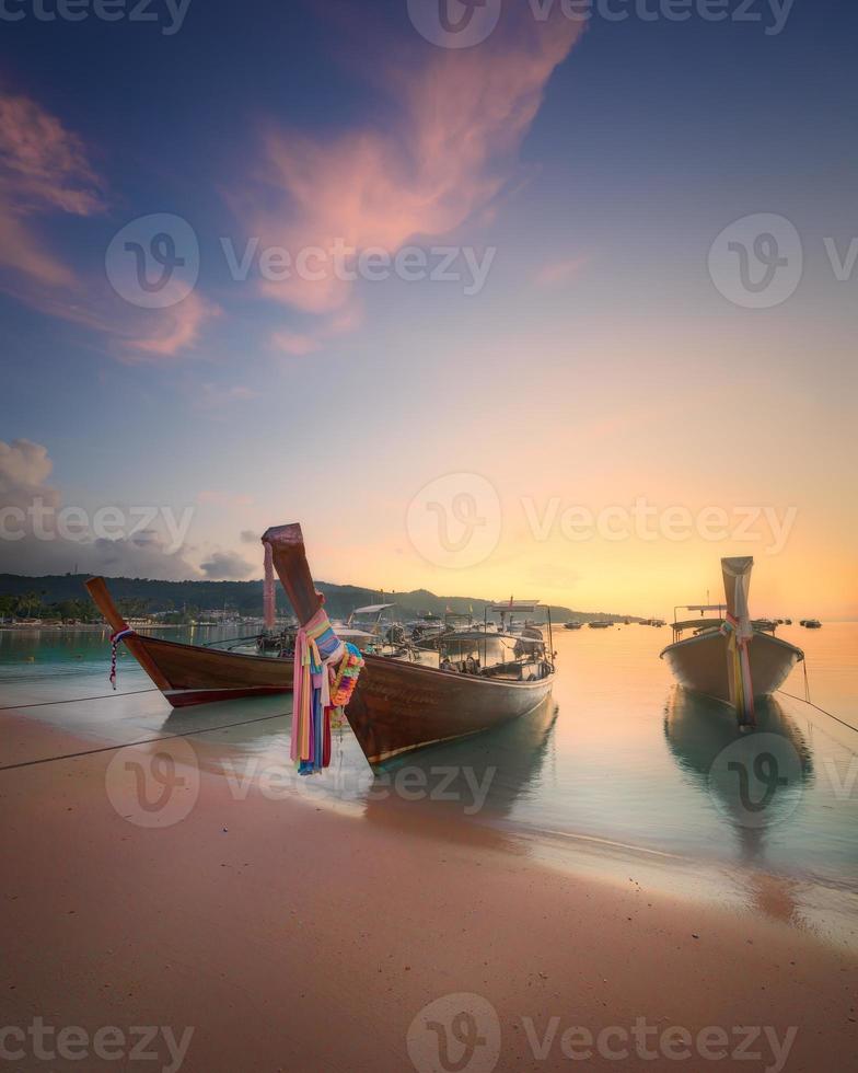 Sonnenaufgang mit buntem Himmel und Boot am Strand foto