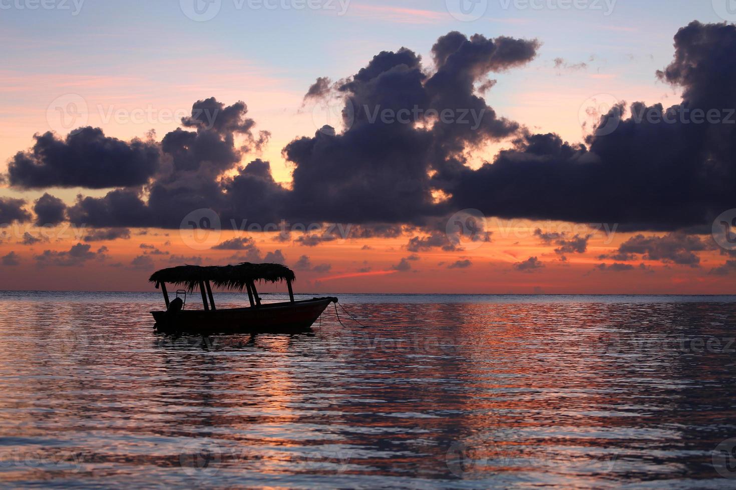 Silhouette eines Bootes bei Sonnenaufgang foto