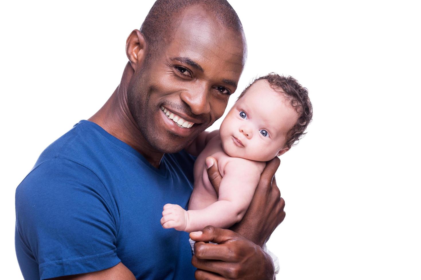 glücklicher Vater. glücklicher junger afrikanischer mann, der sein kleines baby hält und lächelt, während er isoliert auf weiß steht foto