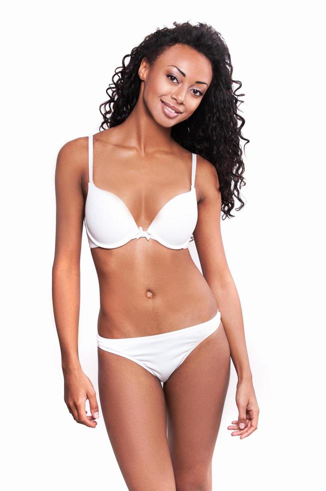 gesund und schön. attraktive junge afroamerikanische Frau in weißem BH und Höschen posiert vor weißem Hintergrund foto