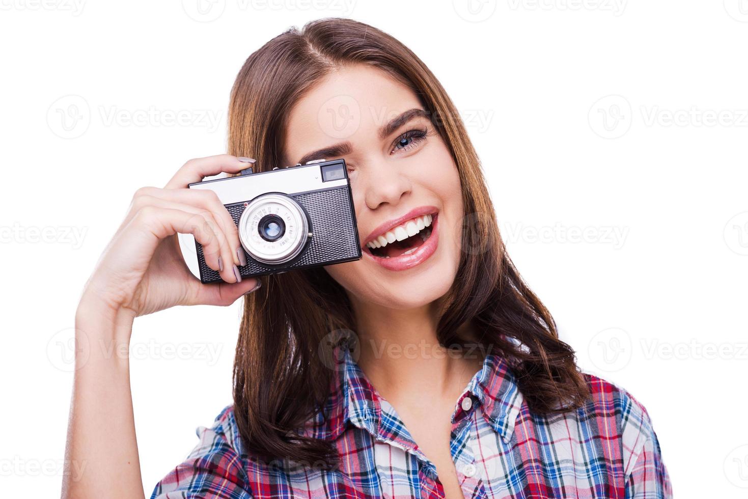 Experte für Fotografie. nette junge Frau, die Kamera hält und Foto beim Stehen gegen weißen Hintergrund macht